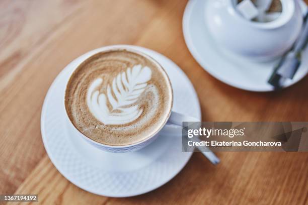 white cup of coffee with latte art, directly above view - mokka stock-fotos und bilder