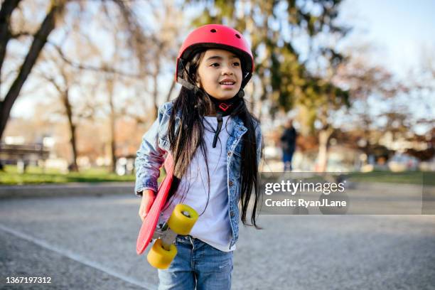 ragazza con skateboard rosso e casco - skateboard foto e immagini stock