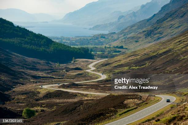 curvy road in the scottish highlands - scottish coastline stock pictures, royalty-free photos & images