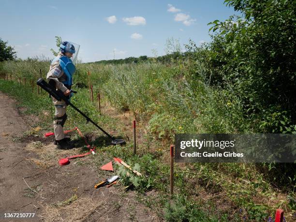 Svetlana, 46 years-old, deminer and deputy team leader in Danish Demining Group , probes the ground with her detector in search of war's explosive...