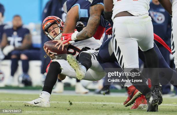 Joe Burrow of the Cincinnati Bengals is sacked by the Tennessee Titans during the AFC Divisional Playoff at Nissan Stadium on January 22, 2022 in...