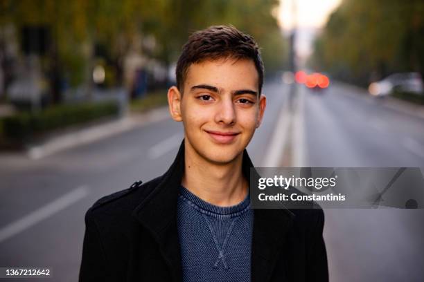 lächelnder 15-jähriger kaukasischer teenager auf der straße der stadt - 16 17 years stock-fotos und bilder