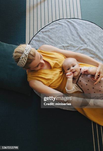 portrait of happy mother and her child lying on their back and cuddling - children circle floor stock pictures, royalty-free photos & images