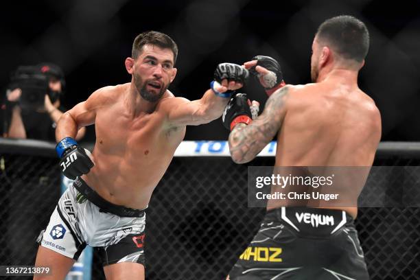Dominick Cruz punches Pedro Munhoz of Brazil in their bantamweight bout during the UFC 269 on December 11, 2021 in Las Vegas, Nevada. On December 11,...