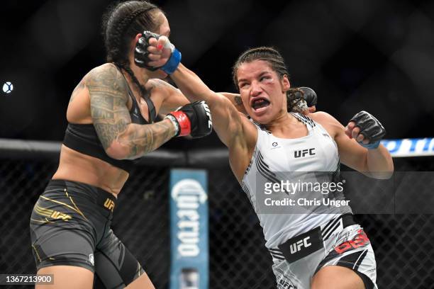 Julianna Pena punches Amanda Nunes of Brazil in their women's bantamweight championship bout during UFC 269 at T-Mobile Arena on December 11, 2021 in...