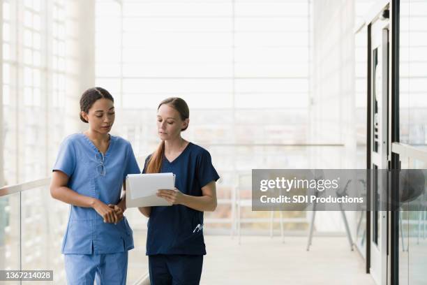 female surgeons discuss cases - two doctors talking stockfoto's en -beelden