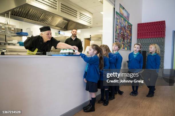 school children queuing for snacks in lunch hall - kids lining up stock pictures, royalty-free photos & images