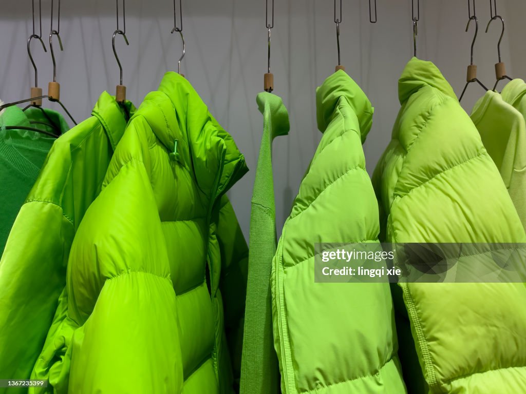 Green down jacket hanging on clothes rack