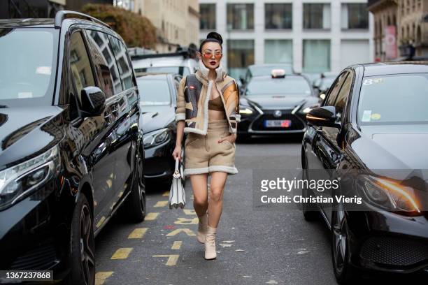Jessica Wang seen wearing white Fendi bag, shorts in beige, Fendi boot, cropped top in brown, shearling jacket outside Fendi during Paris Fashion...