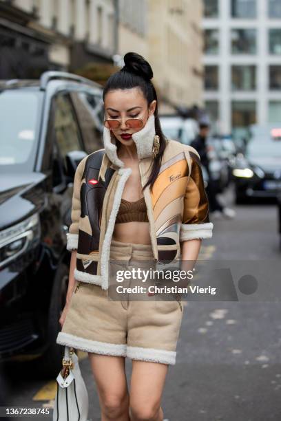 Jessica Wang seen wearing white Fendi bag, shorts in beige, Fendi boot, cropped top in brown, shearling jacket outside Fendi during Paris Fashion...