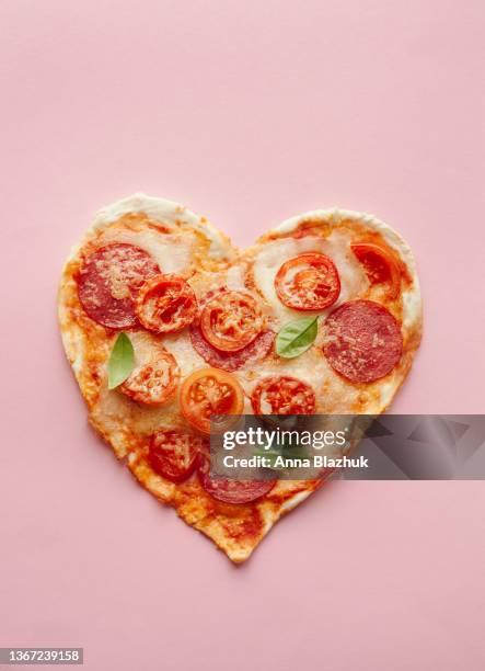 pizza of heart shape with pepperoni and mozarella cheese. card for valentine's day. - pepperoni pizza 個照片及圖片檔