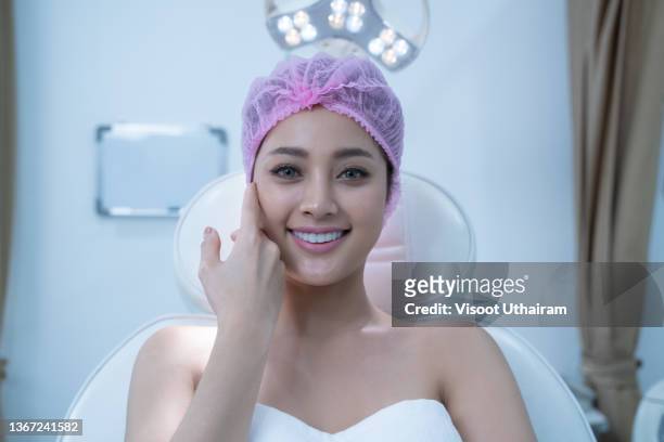 portrait of beautiful asian woman face in cosmetological clinic,girl hand touch cheek and smile attractive,face of beauty perfect. - odontología cosmética fotografías e imágenes de stock