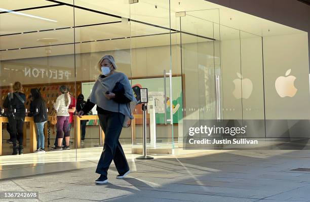 Pedestrian walks by an Apple store on January 27, 2022 in Corte Madera, California. Apple reported record first-quarter earnings with $123.9 billion...