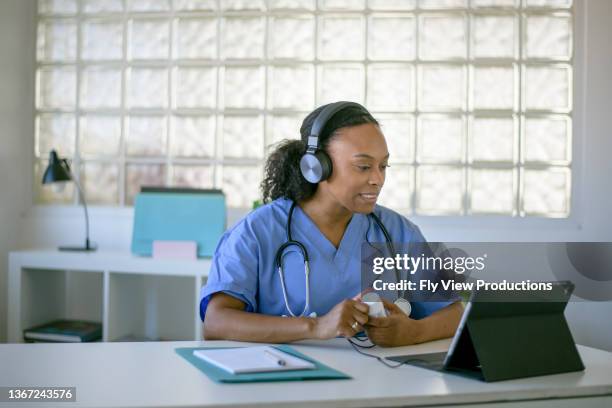 female doctor working at her office doing telemedicine services - telemedicine visit stock pictures, royalty-free photos & images