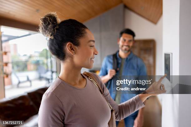 couple leaving their house and setting the alarm using a home automated system - smart home stock pictures, royalty-free photos & images