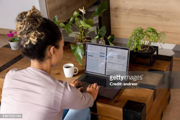 woman at home checking her bank statements online - online banking stock pictures, royalty-free photos & images
