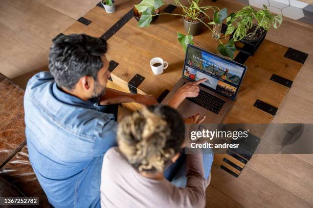 feliz pareja en casa reservando un viaje online - hacer una reserva fotografías e imágenes de stock