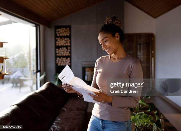 woman at home checking her mail - utility bill envelope stock pictures, royalty-free photos & images