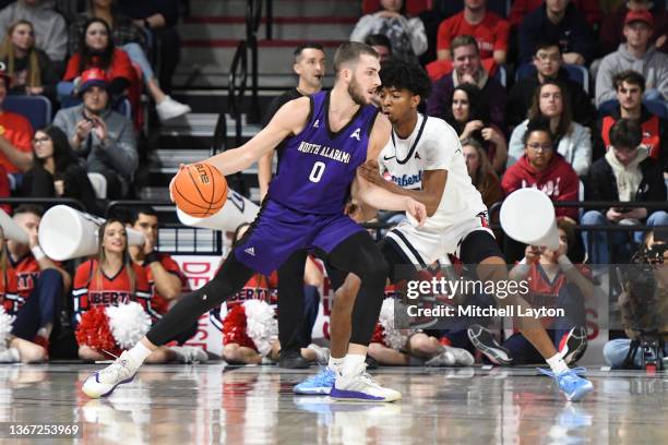 Will Soucie of the Liberty Flames dribbles around Isiah Warfield of the Liberty Flames in the first against the North Alabama Lions at the Liberty...