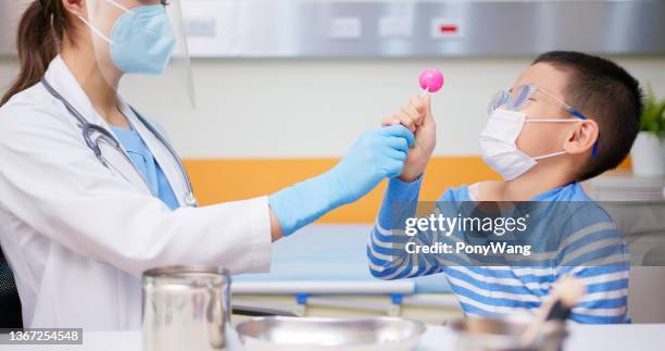 医者は少年にロリポップを与える - candy samples ストックフォトと画像