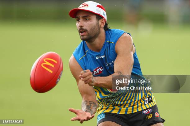 Izak Rankine handballs during the Gold Coast Suns AFL training session at Metricon Stadium on January 28, 2022 in Gold Coast, Australia.