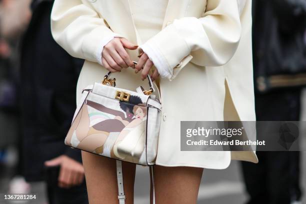 Amelie Zilber wears a gold large pendant earring from Fendi, a white shoulder-off short dress, a white latte jacket from Fendi, white matte First...