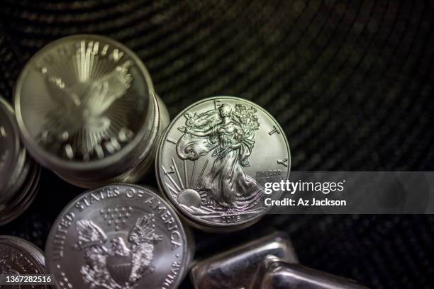 top view of stacks of gold & silver coins against a dark background focusing on the american eagle us liberty one dollar coin - moeda de um dólar dos estados unidos imagens e fotografias de stock