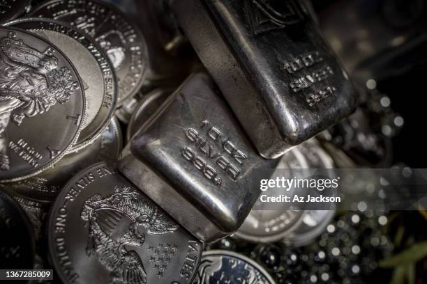 a pile of silver bullion bars and coins against a dark background - couleur argentée photos et images de collection