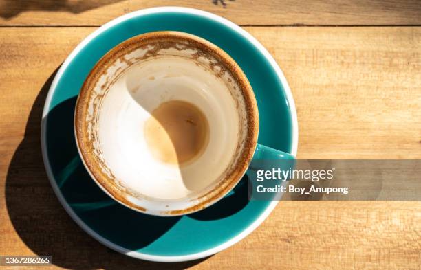 an empty glass cup of coffee on the wooden table. high angle view of a cup of coffee. - bare bottom stock pictures, royalty-free photos & images