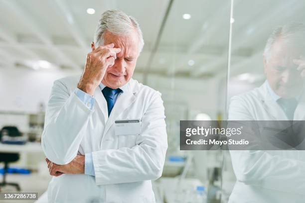 shot of a senior scientist looking stressed out while working in a lab - smart studio shot stockfoto's en -beelden