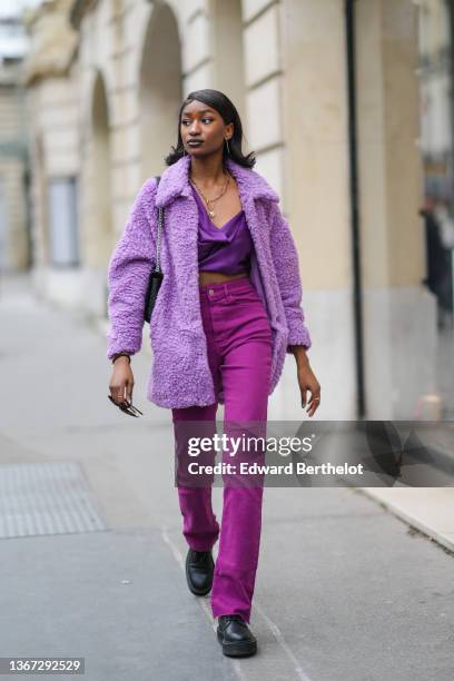 Guest wears rhinestones pendant earrings, gold chain pendant necklace, a purple V-neck / flowing cropped t-shirt, a pale purple fluffy coat, a black...