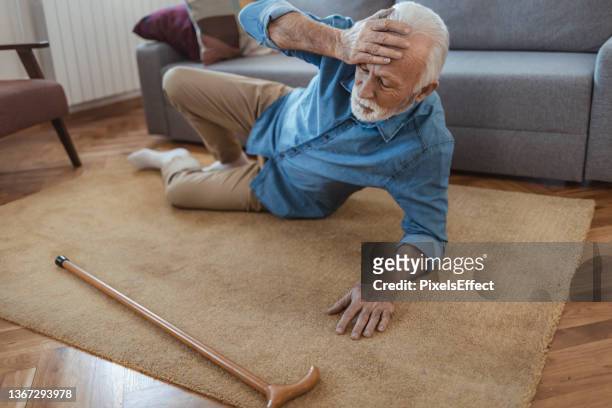 disabled senior man lying on carpet - falling bildbanksfoton och bilder