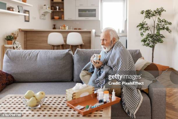 sick senior man with fever wrapped in warm blanket - pneumonia elderly stock pictures, royalty-free photos & images