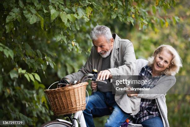 happy senior couple cycling in nature. - fietsen genieten stockfoto's en -beelden