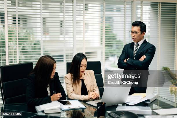 an asian manager is insulting his colleague in conference room - workplace bullying stock pictures, royalty-free photos & images