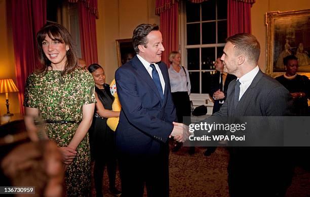 Prime Minister David Cameron shakes hands with singer Gary Barlow during a celebratory reception for BBC Children In Need hosted by Samantha Cameron...