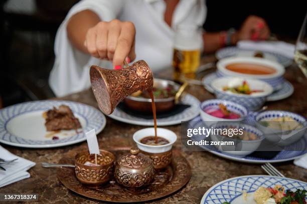 pouring coffee from copper pot in cup, traditional in middle eastern culture - cezve stockfoto's en -beelden