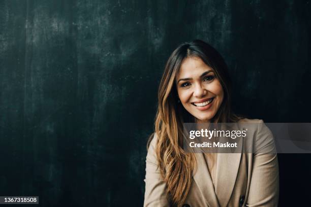 smiling female professional against wall in office during pandemic - portrait studio sourire corporate photos et images de collection