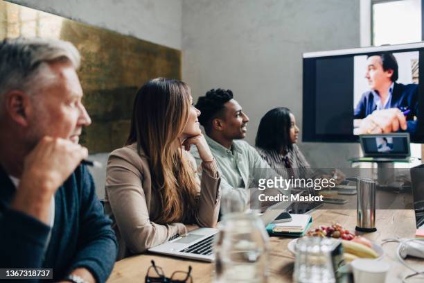 female and male professionals discussing in meeting at office during covid-19 - remote location stock pictures, royalty-free photos & images