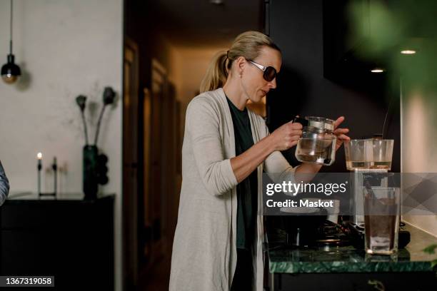 blind woman preparing coffee in kitchen - blind woman stock pictures, royalty-free photos & images