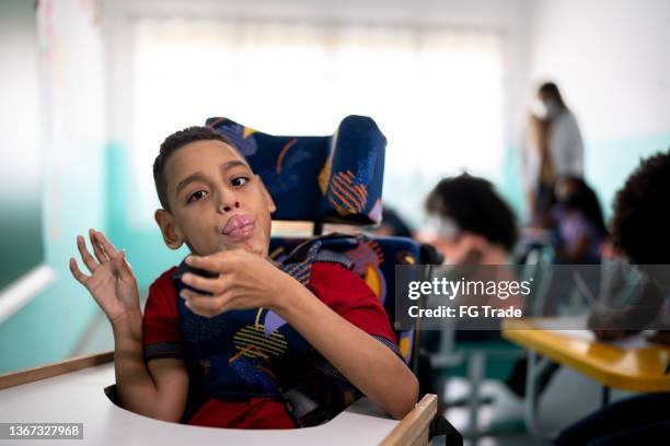 portrait of a boy with special needs in the classroom - cerebral palsy stock pictures, royalty-free photos & images