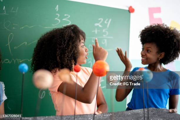 girls doing a presentation about the solar system in the classroom - preteen girl models stock pictures, royalty-free photos & images