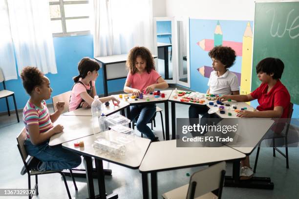 kids separating recycling materials in the classroom - criança de escola primária imagens e fotografias de stock