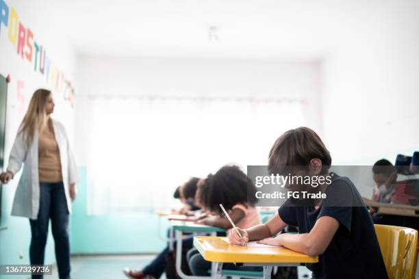 boy taking notes in the classroom - 13 year old cute boys stock pictures, royalty-free photos & images