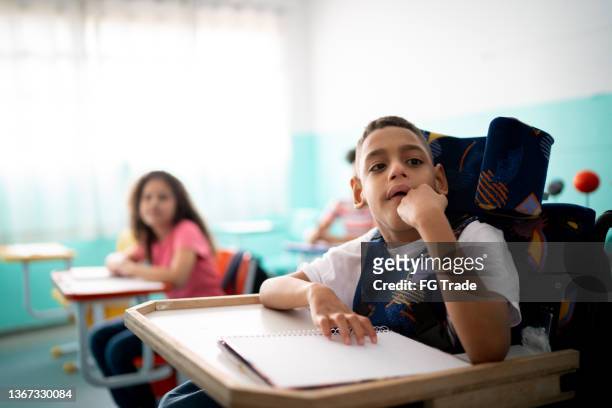 boy with special needs in the classroom - cerebal palsy stockfoto's en -beelden
