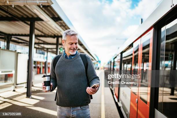 hombre de negocios maduro que viaja y usa un teléfono inteligente - trein nederland fotografías e imágenes de stock