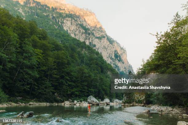 female traveler refreshing in the river inside the scenic mountain canyon in montenegro - women in skimpy bathing suits stock pictures, royalty-free photos & images