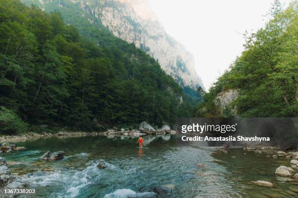 female traveler refreshing in the river inside the scenic mountain canyon in montenegro - skimpy bathing suits stock pictures, royalty-free photos & images