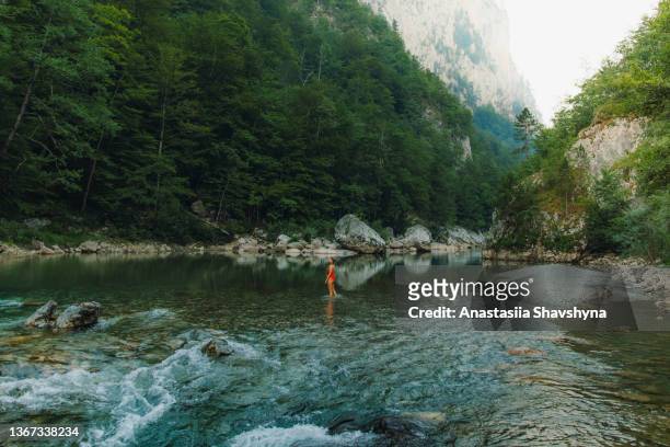 female traveler refreshing in the river inside the scenic mountain canyon in montenegro - skimpy bathing suits stock pictures, royalty-free photos & images