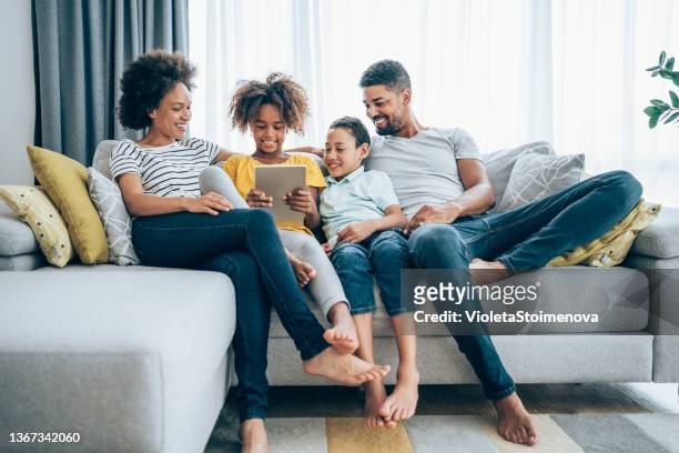 relaxing at home with wireless technology. - father and daughter looking at smartphone together stock pictures, royalty-free photos & images